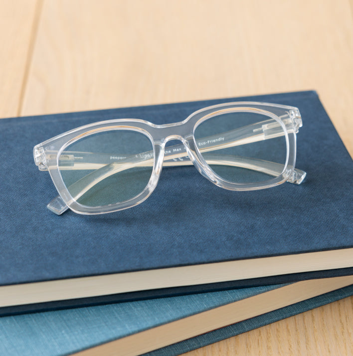 Clear reading glasses on blue books