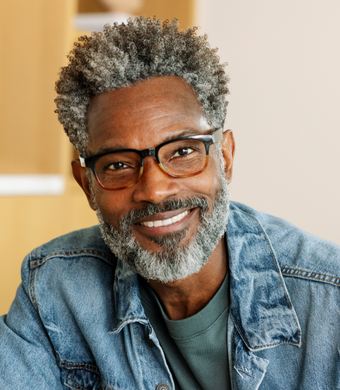 Man wearing black reading glasses smiling 