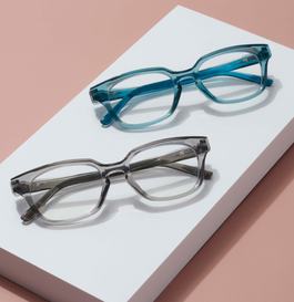 Gray and blue reading glasses on a pink background