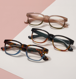 three pairs of reading glasses on a white and pink background