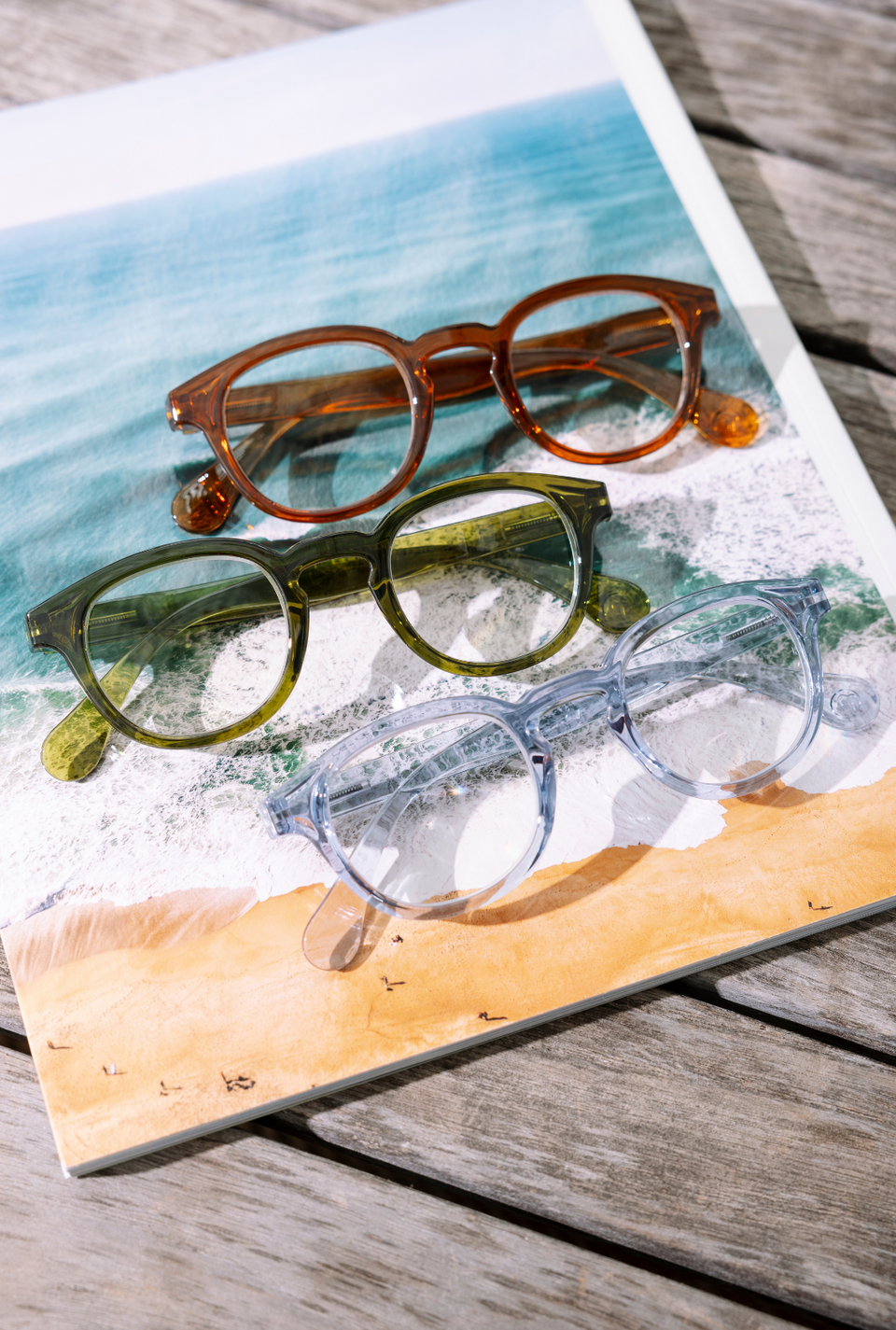 Three pairs of reading sitting on a magazine of the ocean