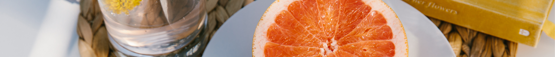 Main hero: Orange on a plate next to a book and glass of water