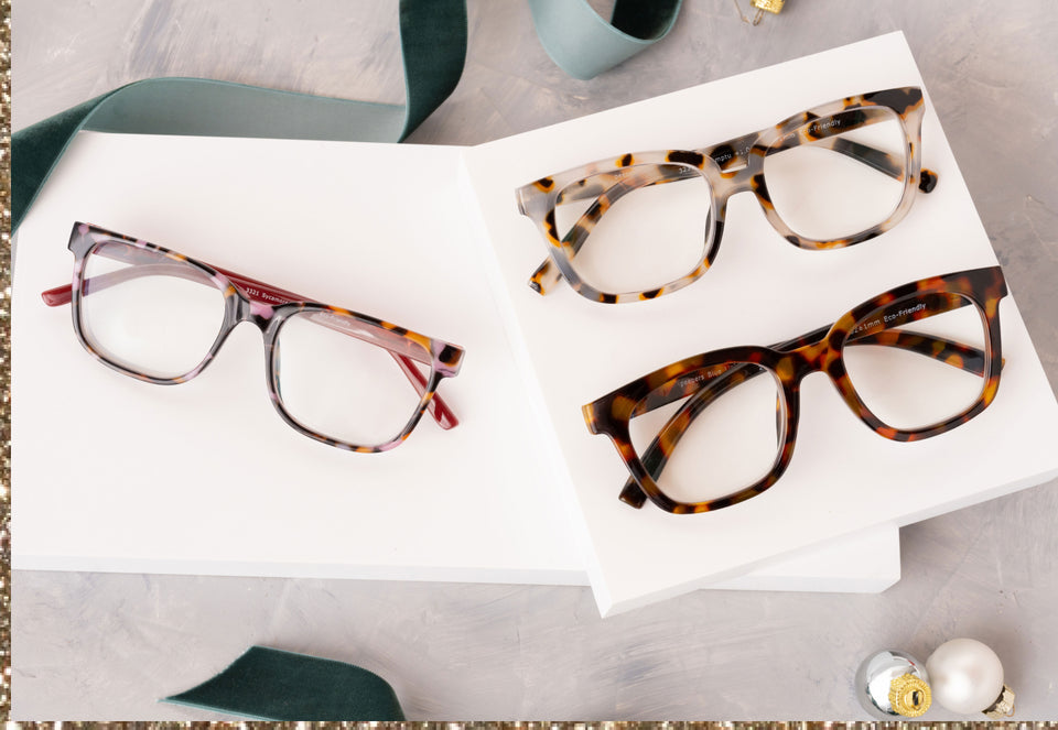 Flat lay of three pairs of glasses near holiday decorations